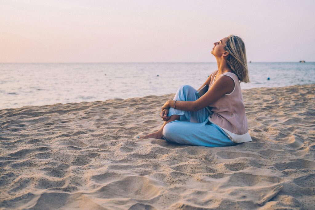 Mulher praticando respiração consciente ao ar livre para aliviar a ansiedade.